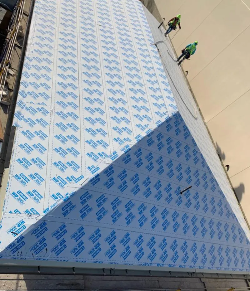 Professional roofers installing underlayment on a metal roof in Deptford